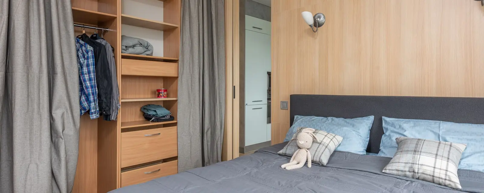 Studio de Airbnb com cama arrumada, armário e iluminação aconchegante