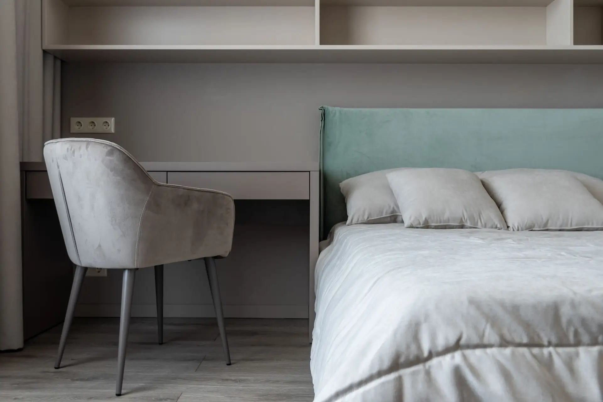 Quarto de apartamento de Airbnb com cama de lençóis claros e escrivaninha