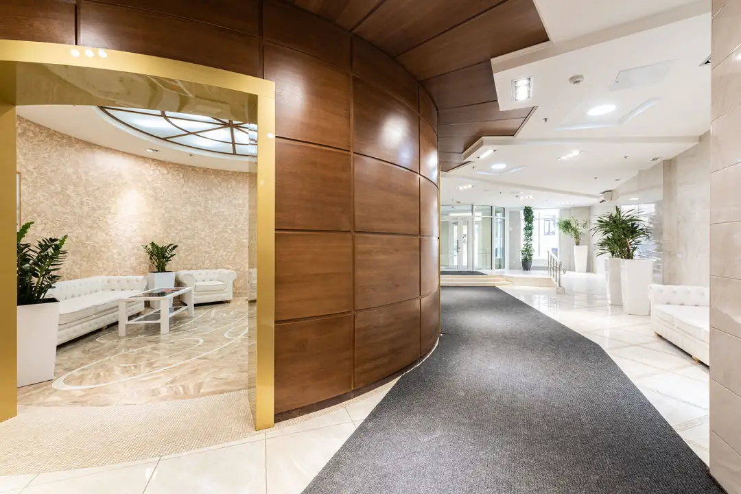 Corredor de hotel com revestimento de madeira e plantas