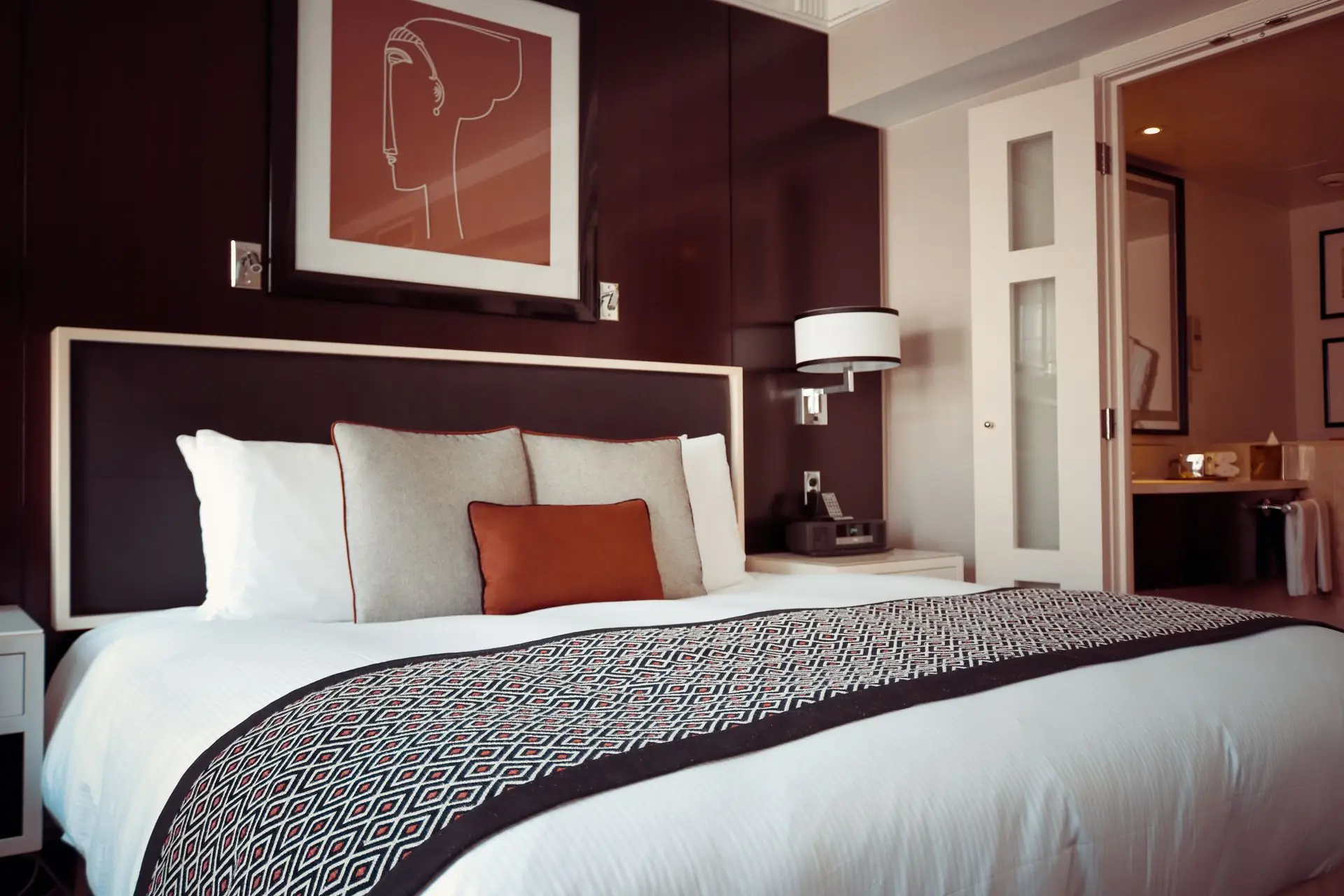 Cama de hotel arrumada com enxoval branco de padrão hoteleiro